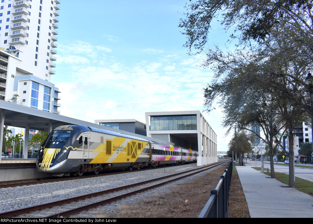 Brightline Bright Pink train at West Palm Beach Station heading southbound to Miami 